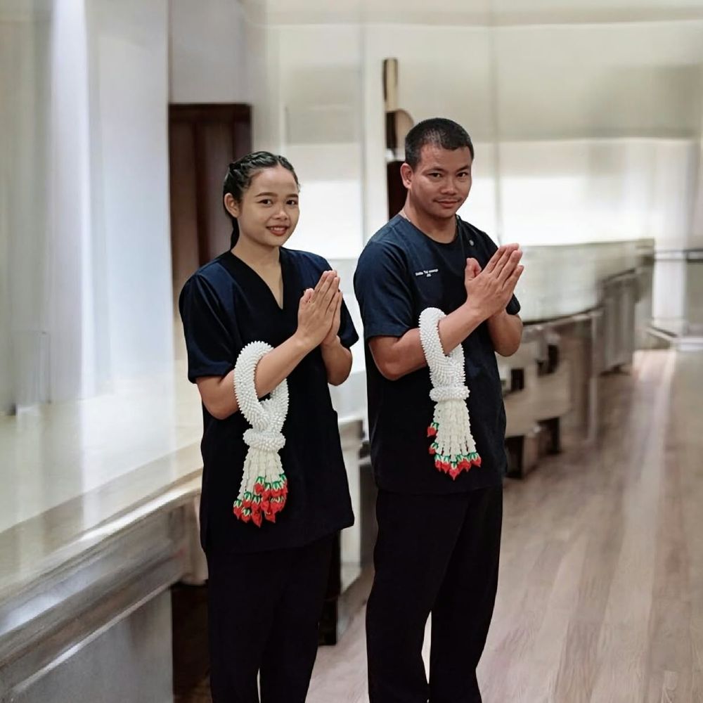 Two Dahlia therapists greeting with a Thai wai and jasmine garlands
